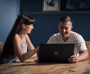 Young couple smiling while looking at laptop