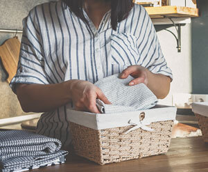 Woman folding away dishtowels in kitchen