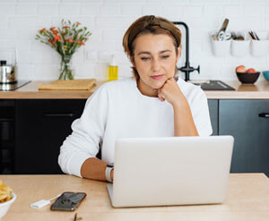 Woman on laptop in kitchen