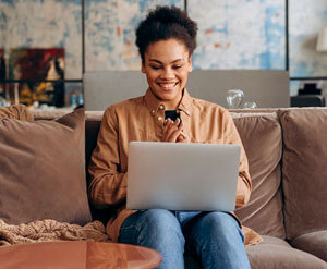 Woman smiling on laptop on her couch
