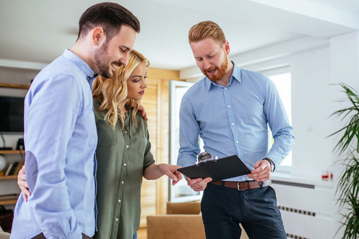Agent going through check list with a couple selling their home
