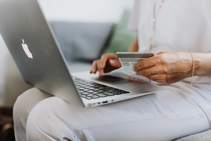 Woman entering card details on laptop to make online purchase
