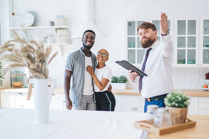 Agent and potential buyers inspecting the kitchen